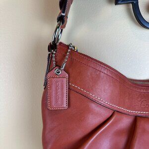 Coach boho bag burnt orange. Silver trim. Back pocket. Zipper closure. key ring